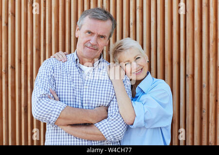 Jusqu'à la taille de maturité contemporaine portrait couple posing together outdoors article par fond de bois, copy space Banque D'Images