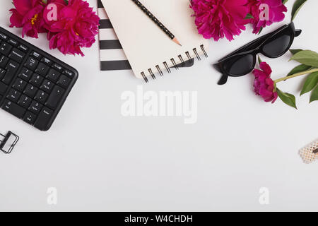 Cadre créatif avec de beaux accessoires féminins, les fournitures de bureau et de pivoines rose, vue du dessus Banque D'Images