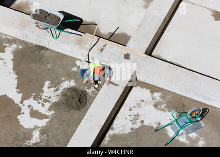 Les travailleurs en uniforme sable propre sur un site de construction, vue d'en haut. Banque D'Images