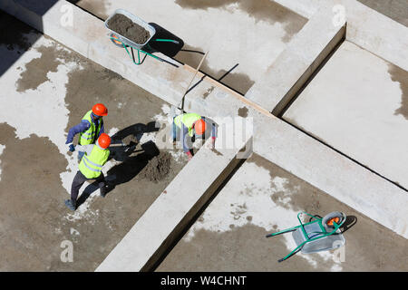 Les travailleurs en uniforme sable propre sur un site de construction, vue d'en haut. Banque D'Images