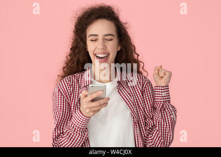 Fille excité message reçu une opportunité incroyable posant isolé sur pink Banque D'Images