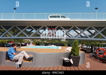 Riverboat passant sous un pont très bas, la piscine balustrade et tour de communication réduit, les gens assis, haut d'une terrasse, d'Europe, le fleuve Douro, Portugal, le SPIR Banque D'Images