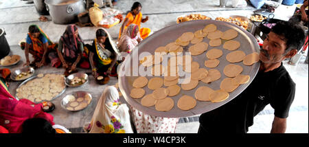 Jammu, en Inde . 22 juillet, 2019. Un homme porte un plateau de Chapattis que les femmes préparent la nourriture pour les dévots à saint Amarnath Yatra camp de base au Jammu, capitale de l'hiver, le Cachemire sous contrôle indien le 22 juillet 2019. Source : Xinhua/Alamy Live News Banque D'Images