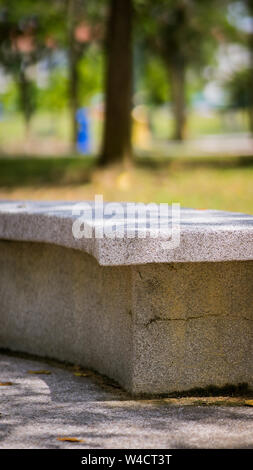 Banc en pierre recouvert de lavage de galets dans un parc extérieur. Banque D'Images