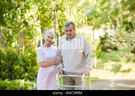 Portrait of senior man posing walker avec son épouse à l'extérieur dans le parc ensoleillé, copy space Banque D'Images