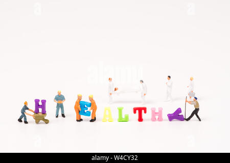 Mot du texte coloré en bonne santé avec l'équipe de santé et personnes miniature background Banque D'Images