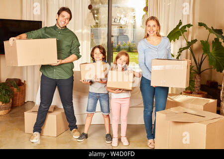 Les parents et deux enfants avec des cartons dans la nouvelle maison ou l'appartement Banque D'Images