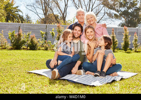 Grande famille heureuse avec trois générations ensemble dans le jardin en été Banque D'Images