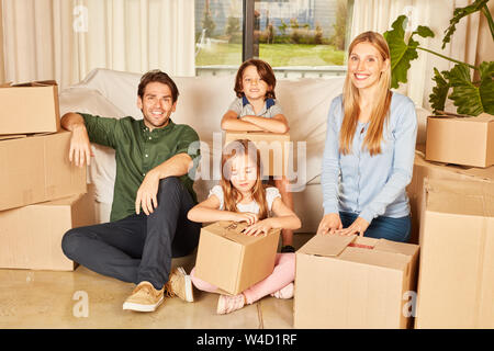 Famille avec deux enfants entre les cartons de déménagement dans la nouvelle maison ou nouvel appartement Banque D'Images