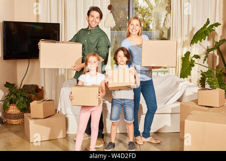 Famille heureuse avec deux enfants est debout avec des cartons dans le nouvel appartement Banque D'Images