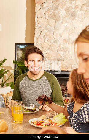 Père avec sa fille et épouse à déjeuner ou dîner en bonne santé à la maison Banque D'Images