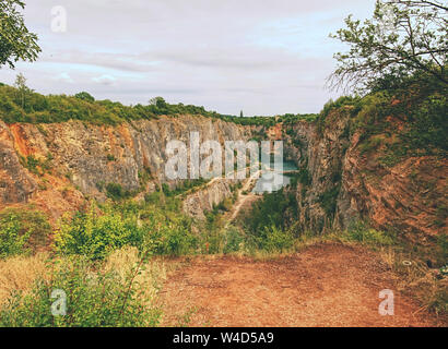 Grande ancienne carrière d'extraction de dolomie. Blue Lagoon en milieu avec pont en bois pour les touristes. Banque D'Images