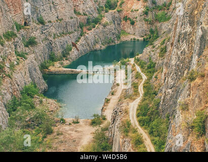 Grande ancienne carrière d'extraction de dolomie. Blue Lagoon en milieu avec pont en bois pour les touristes. Banque D'Images