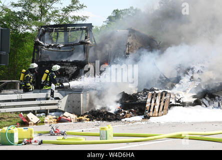 Karlsruhe, Allemagne. 22 juillet, 2019. Les pompiers éteindre les véhicules sur l'autoroute 5, près de Karlsruhe. Après une collision par l'arrière entre un camion et une voiture sur l'autoroute, un incendie éclate. Selon un porte-parole de la police, les détails de la cause et les éventuelles victimes n'étaient pas connus au début. Selon des témoins, le développement de fumée pourrait être vu de nombreux kilomètres. Credit : Uli Deck/dpa/Alamy Live News Banque D'Images