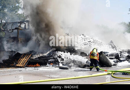 Karlsruhe, Allemagne. 22 juillet, 2019. Les pompiers éteindre les véhicules sur l'autoroute 5, près de Karlsruhe. Après une collision par l'arrière entre un camion et une voiture sur l'autoroute, un incendie éclate. Selon un porte-parole de la police, les détails de la cause et les éventuelles victimes n'étaient pas connus au début. Selon des témoins, le développement de fumée pourrait être vu de nombreux kilomètres. Credit : Uli Deck/dpa/Alamy Live News Banque D'Images