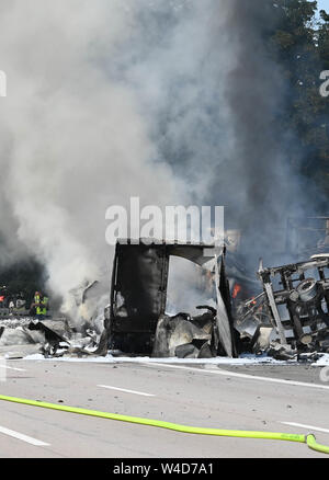 Karlsruhe, Allemagne. 22 juillet, 2019. Les pompiers éteindre les véhicules sur l'autoroute 5, près de Karlsruhe. Après une collision par l'arrière entre un camion et une voiture sur l'autoroute, un incendie éclate. Selon un porte-parole de la police, les détails de la cause et les éventuelles victimes n'étaient pas connus au début. Selon des témoins, le développement de fumée pourrait être vu de nombreux kilomètres. Credit : Uli Deck/dpa/Alamy Live News Banque D'Images