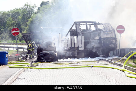 Karlsruhe, Allemagne. 22 juillet, 2019. Les pompiers éteindre les véhicules sur l'autoroute 5, près de Karlsruhe. Après une collision par l'arrière entre un camion et une voiture sur l'autoroute, un incendie éclate. Selon un porte-parole de la police, les détails de la cause et les éventuelles victimes n'étaient pas connus au début. Selon des témoins, le développement de fumée pourrait être vu de nombreux kilomètres. Credit : Uli Deck/dpa/Alamy Live News Banque D'Images