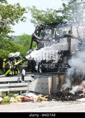 Karlsruhe, Allemagne. 22 juillet, 2019. Les pompiers éteindre les véhicules sur l'autoroute 5, près de Karlsruhe. Après une collision par l'arrière entre un camion et une voiture sur l'autoroute, un incendie éclate. Selon un porte-parole de la police, les détails de la cause et les éventuelles victimes n'étaient pas connus au début. Selon des témoins, le développement de fumée pourrait être vu de nombreux kilomètres. Credit : Uli Deck/dpa/Alamy Live News Banque D'Images