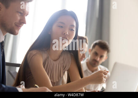 L'accent asian businesswoman looking at laptop professionnel au cours de la réunion du bureau Banque D'Images