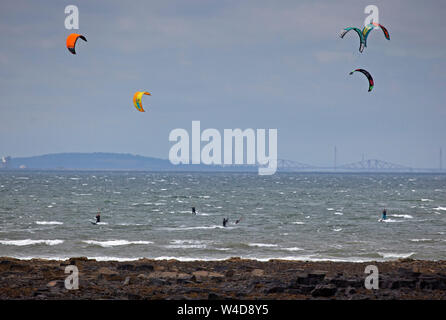 Longniddy virages, East Lothian, Scotland, UK. 22 juillet 2019. Conditions de vent exceptionnelle a encouragé plusieurs kitesurfers et windsurfers deux à relever le défi avec la magnifique toile de fond de siège d'Arthur, le château d'Édimbourg et le Forth Rail Bridge en arrière-plan. Banque D'Images