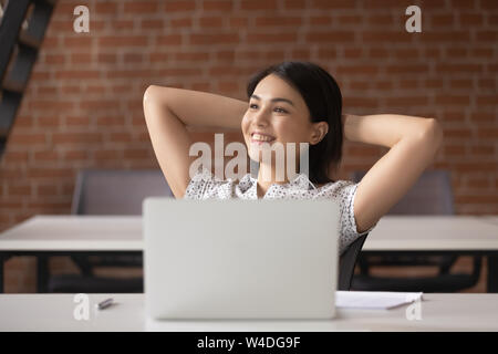 Smiling asian businesswoman décontractée prendre pause pour se reposer sur le lieu de travail Banque D'Images