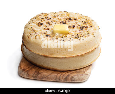 Les crumpets géant avec du beurre fondu sur une planche à découper isolated on white Banque D'Images