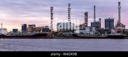 Bannière de l'huile de pétrole raffinerie au bord de la rivière au crépuscule du temps. Processus du pétrole brut machinery Banque D'Images