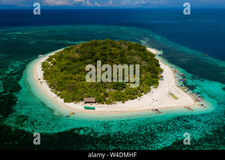 Vue aérienne d'une belle île tropicale entourée de récifs de corail (Mantigue Island, Camiguin, Philippines) Banque D'Images