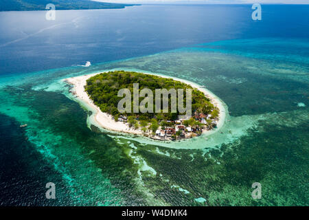 Vue aérienne d'une belle île tropicale entourée de récifs de corail (Mantigue Island, Camiguin, Philippines) Banque D'Images