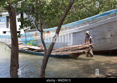 Can Tho, Vietnam - le 24 avril 2014 : la collecte du bois vietnamiens non identifiés sur un bateau à proximité du célèbre marché flottant de Can Tho à Can Tho, Vietnam o Banque D'Images