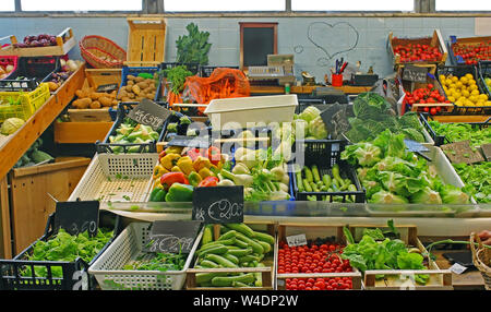 Grande échoppe de marché des produits frais bio légumes pieux dans des caisses en plastique et en bois Banque D'Images