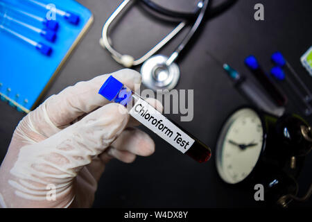 Texte d'essai le chloroforme avec échantillon de sang. Vue de dessus isolé sur fond noir. Concept de soins santé/médecine Banque D'Images