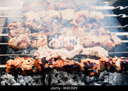 Gros plan d'appétissants sex shish kebab sur des brochettes de métal se prépare sur les charbons à l'extérieur. La cuisson des brochettes sur le gril du barbecue. La préparation de Shish Keba Banque D'Images