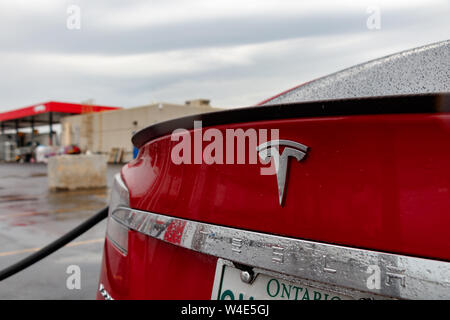 Couvert pluie Tesla Model S Rouge badge et texte. Banque D'Images