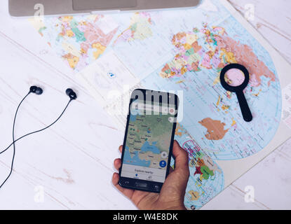 Nizhyn, Ukraine/Juillet-16-2019 : Smartphone et les écouteurs se trouvant sur la carte. Lancement de l'application Google maps. Billet, la destination et l'itinéraire vous pouvez conce Banque D'Images