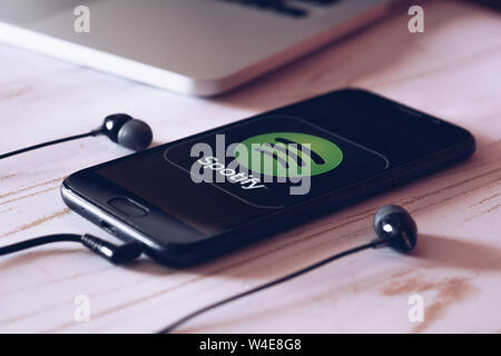 Nizhyn, Ukraine/Juillet-16-2019 : Smartphone allongé sur la table avec l'exécution de la musique Spotify app sur l'écran. Social media concept. Banque D'Images