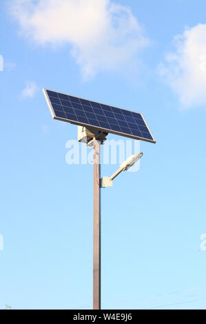 Lampe de rue avec une batterie solaire contre un ciel bleu Banque D'Images