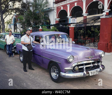 CubanTaxis et pilotes stationné à La Havane. Violette et verte voitures américaines classiques. Banque D'Images