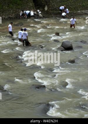 Bogor, Java ouest, Indonésie - Juillet 2019 : un groupe d'hommes travaillent ensemble dans la corbeille cueillette rivière Ciliwung. Banque D'Images