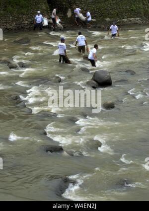 Bogor, Java ouest, Indonésie - Juillet 2019 : un groupe d'hommes travaillent ensemble dans la corbeille cueillette rivière Ciliwung. Banque D'Images