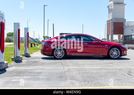 Tesla Model S rouge garée à Tesla Supercharger, recharge. Banque D'Images