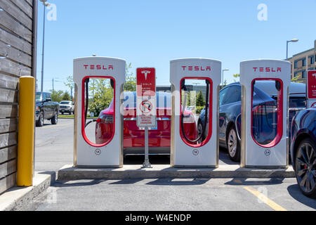 Trois stands de suralimentation Tesla Model S et le modèle X branché à l'arrière. Banque D'Images