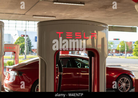 Haut de décrochage compresseur Tesla Tesla Model S Rouge avec charge à l'arrière-plan. Banque D'Images