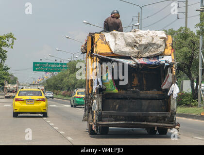 BANGKOK, THAÏLANDE, 03 juin 2019, l'éboueur se trouve sur un camion poubelle en descendant la rue de Bangkok. Banque D'Images