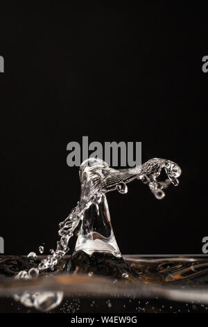 Goutte d'eau, goutte d'eau transparente, de l'eau splash close-up isolé sur fond noir, beaucoup de bulles, liquid motion Banque D'Images