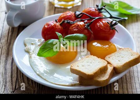 Petit-déjeuner ou un brunch végétarien sain, repas préféré. Oeufs au plat avec des tomates cerises, des fruits d'été, les petits fruits, café et jus de fruits, sur woo rustique Banque D'Images