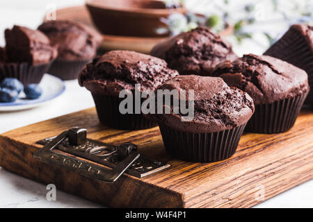 Muffins au chocolat fraîchement cuits faits maison sur planche à découper en bois, Close up, délicieux dessert ou au petit déjeuner Banque D'Images