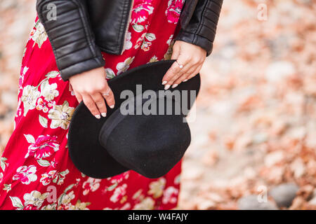 Photo de Black Hat de femmes sur l'arrière-plan d'une robe rouge Banque D'Images