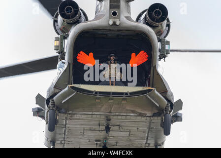 Royal Air Force, RAF hélicoptère Boeing Chinook volant au salon aérien Royal International Air Tattoo, RAF Fairford, Royaume-Uni. Équipage avec de grandes mains Banque D'Images