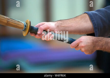 Jeune homme pratiquant le Kendo avec sabre en bois. Banque D'Images